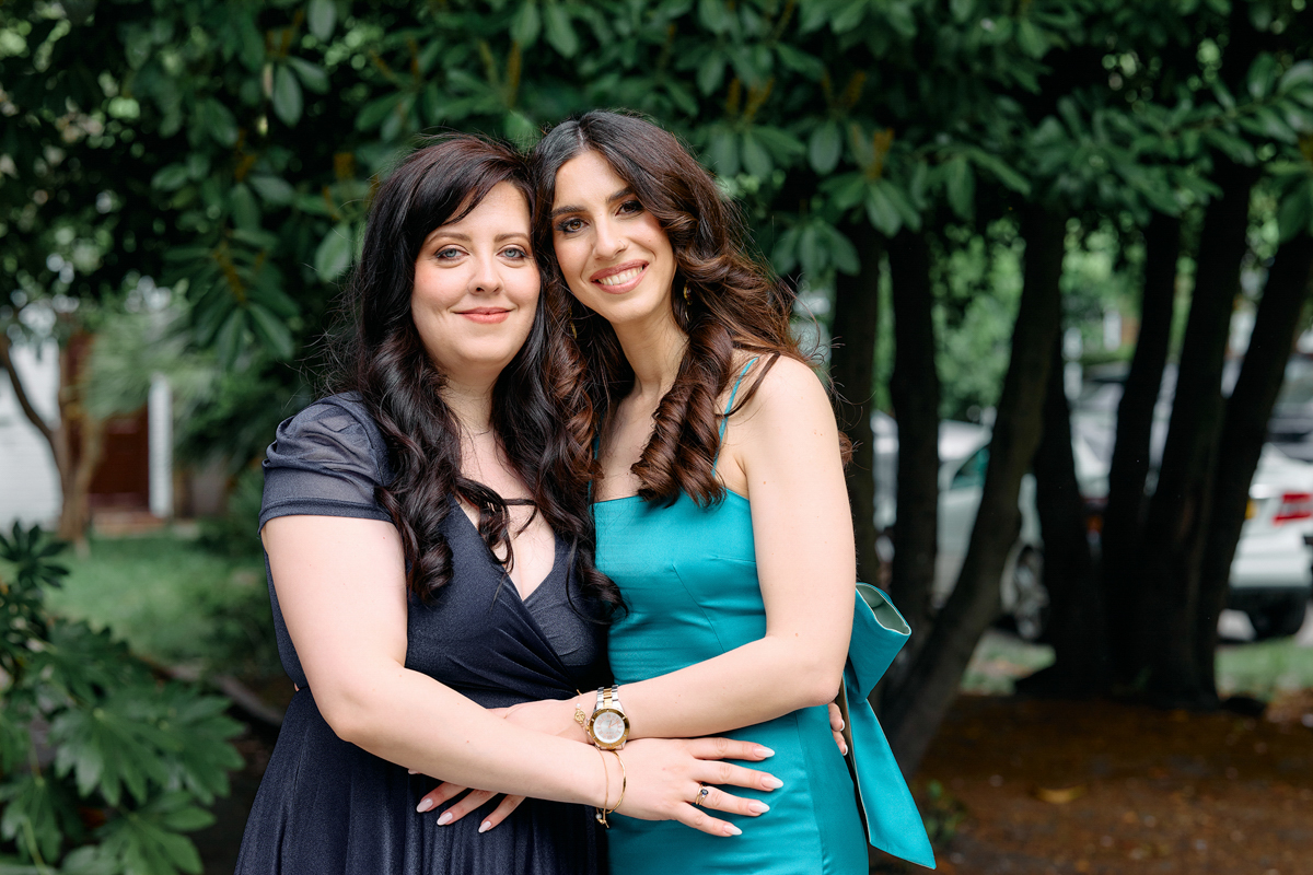 2 ladies posing at the gardne of a church after a christening in London.