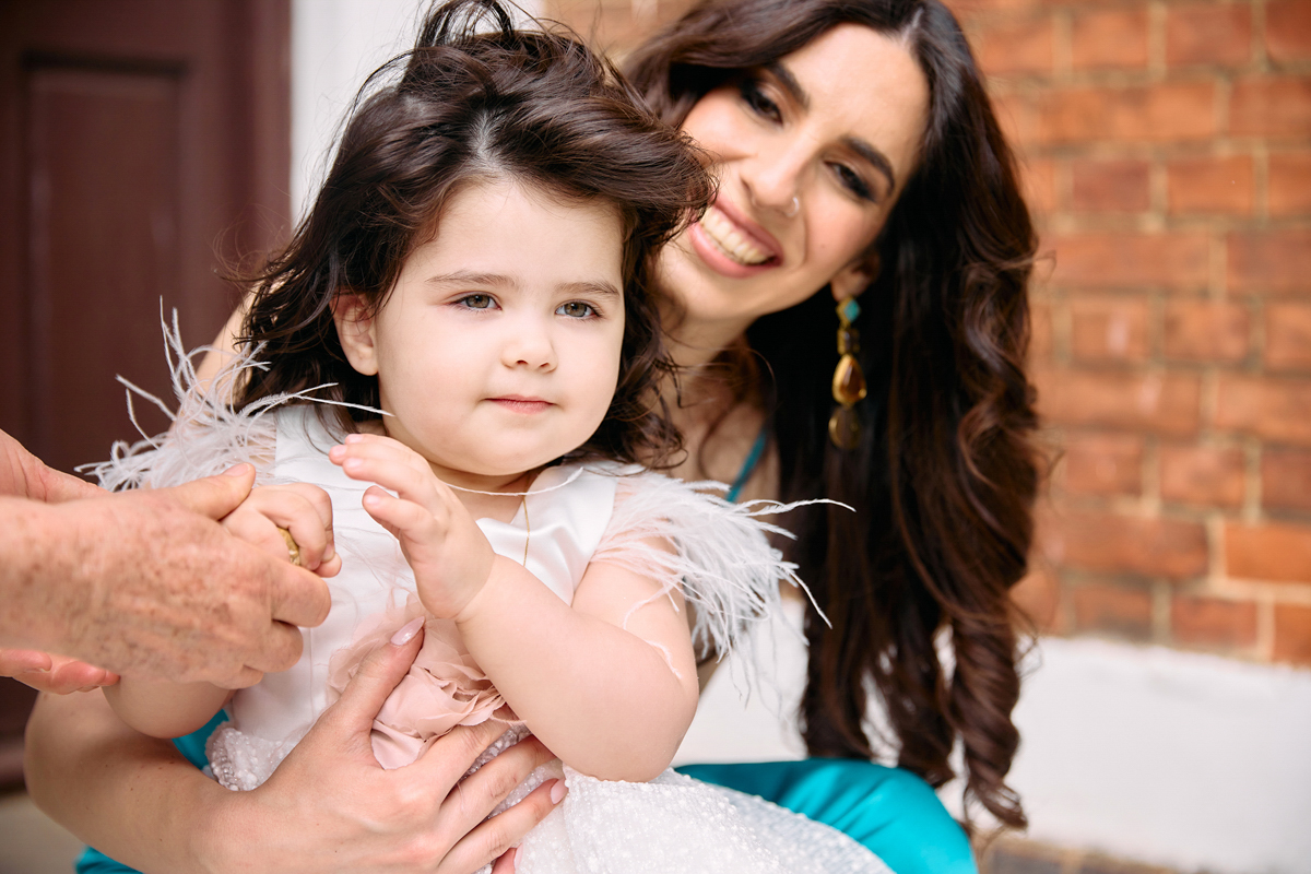 Lady holding little girl outside church after her christening.