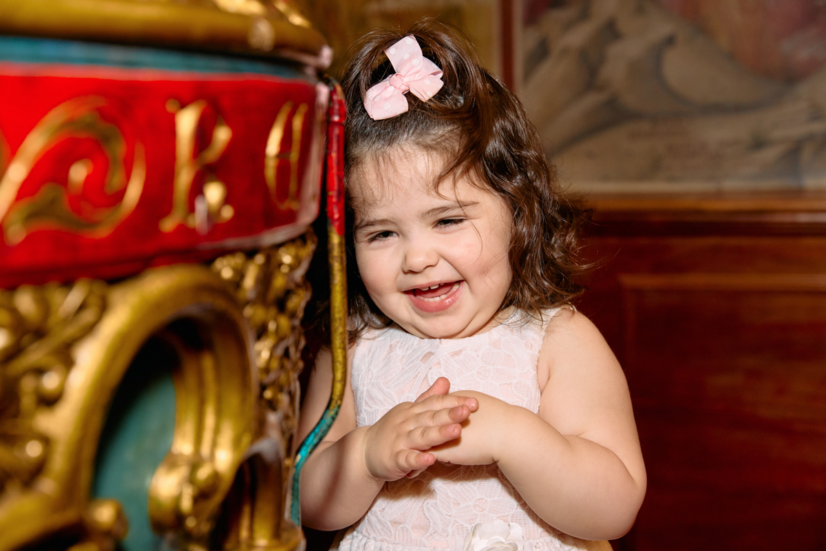 Little girl standing by the baptism fountain and laughing.