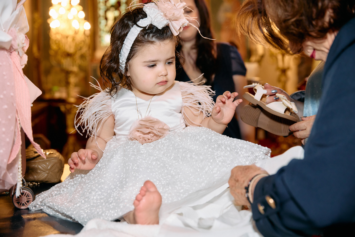 Baby girl getting dressed after her christening in a church.