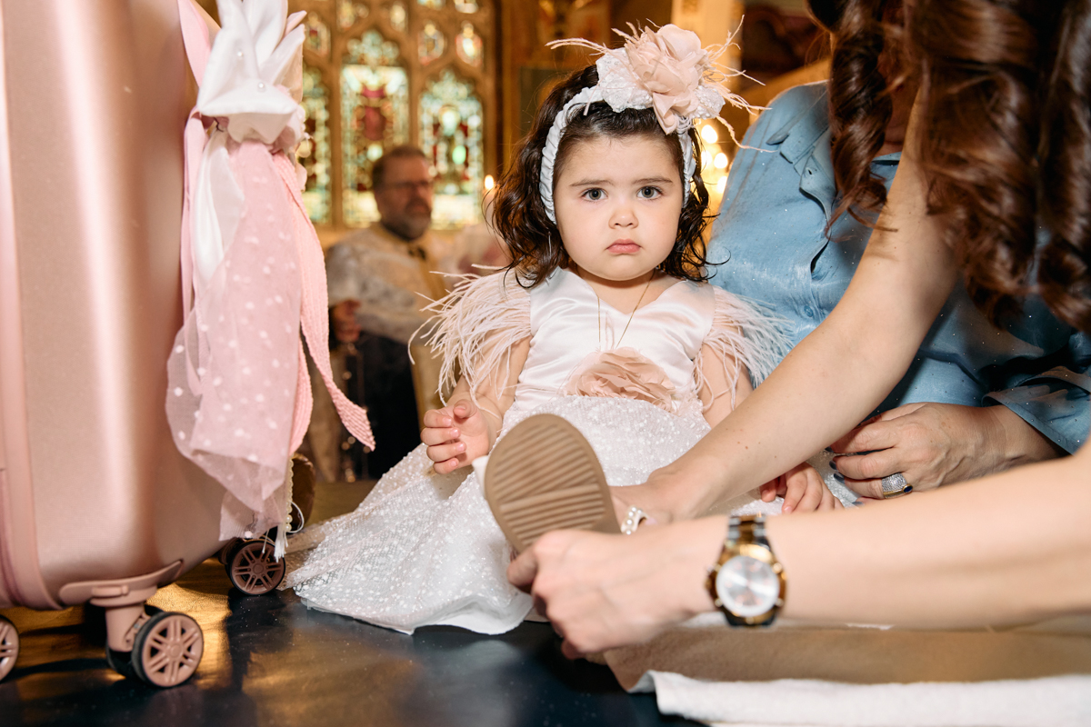 Baby girl getting dressed after her christening in a church.