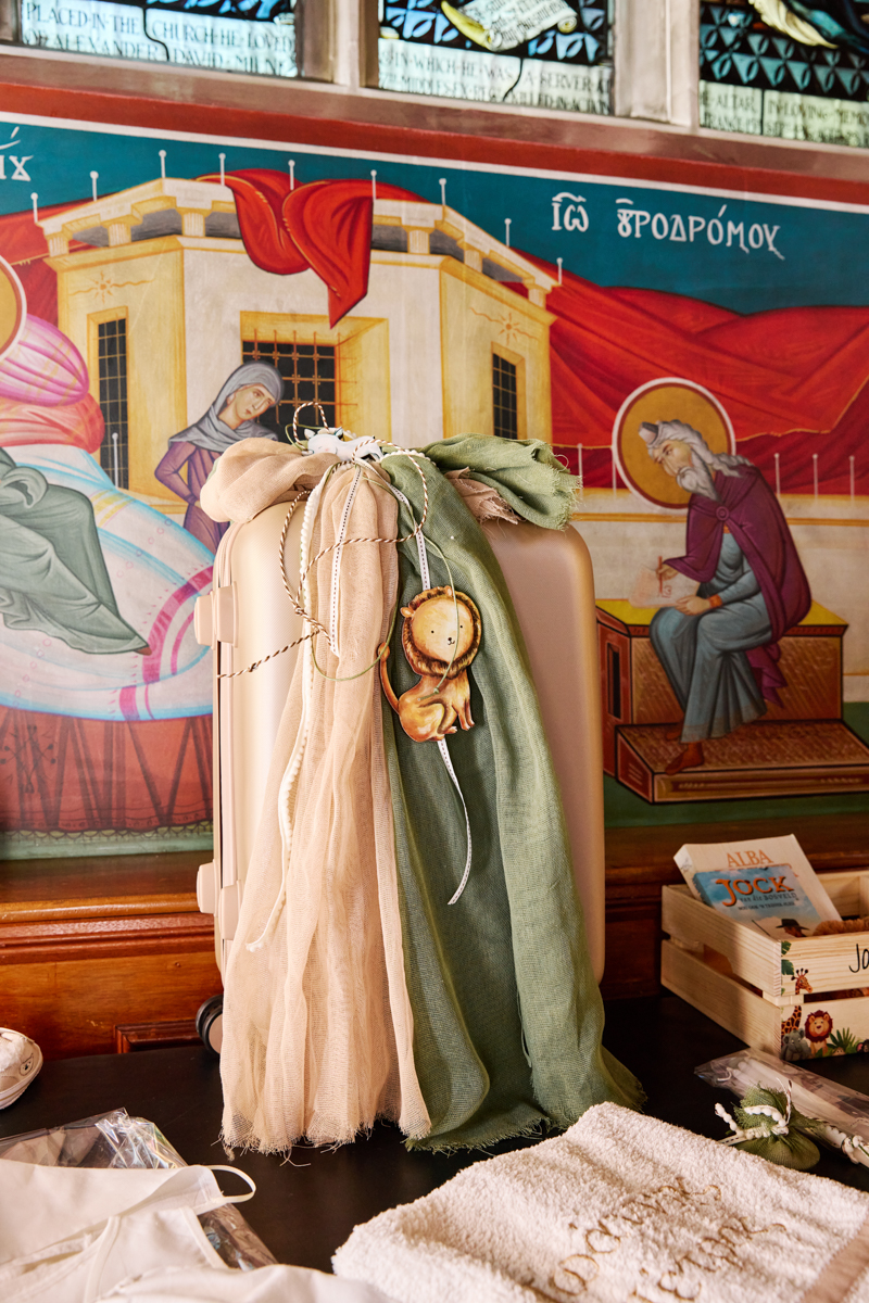 A pink suticase containgin christening clothes in a church.
