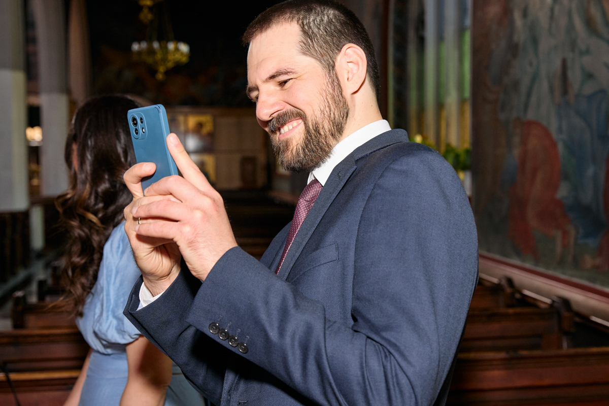 Father taking a photo with a smartphone during the service.