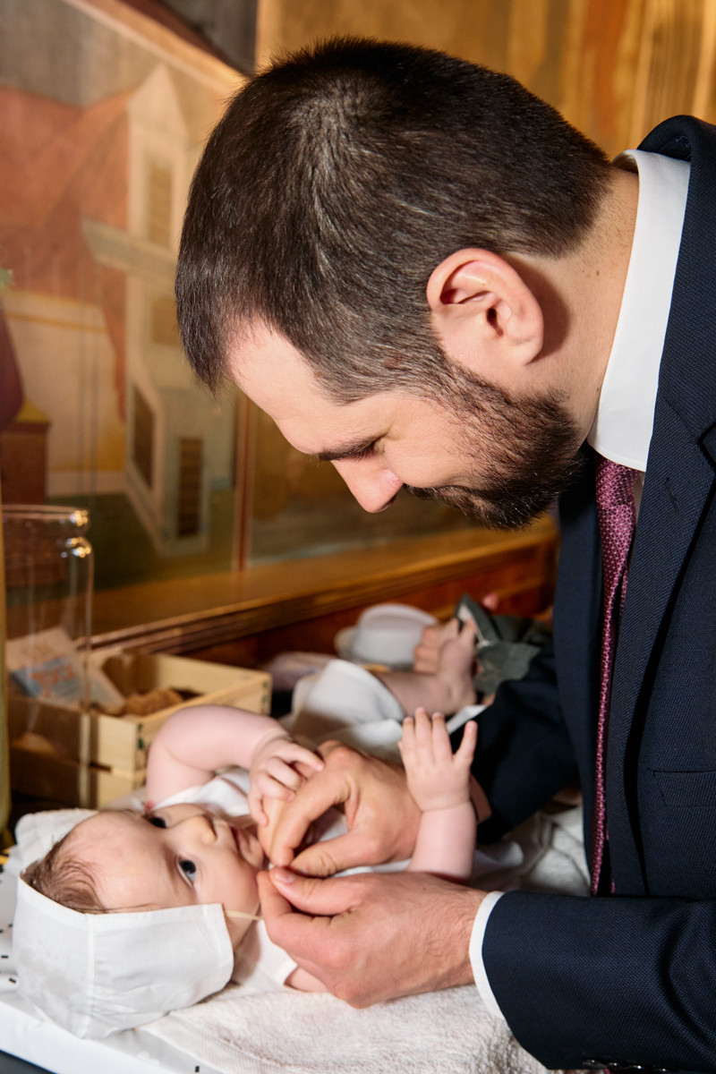 Father drssing up the baby.