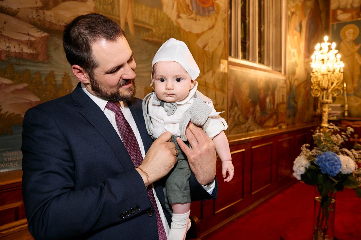 Father holding the baby wearing the christening cap.