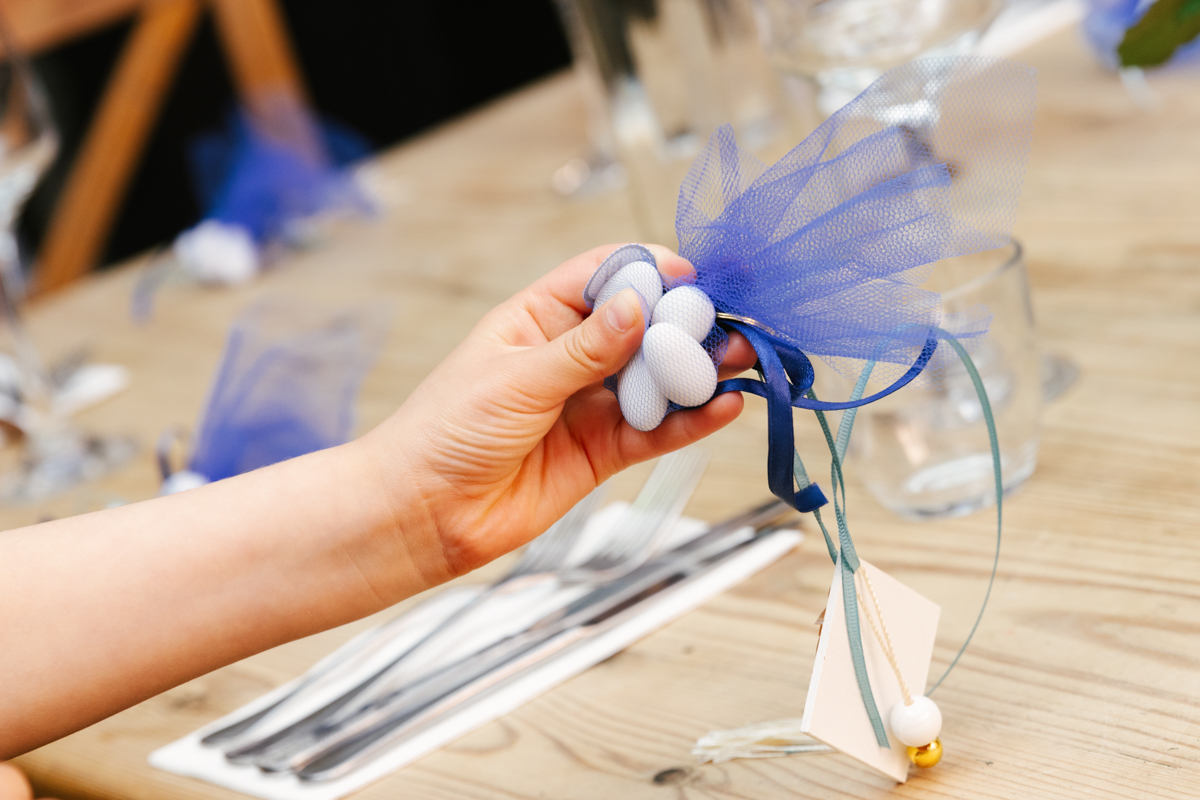 Hand holding a blue-and-white decorative favour.