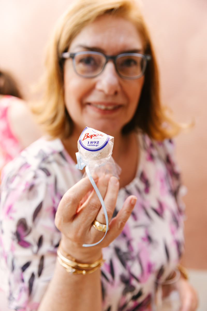 Grandmother holding up a small christening favour.