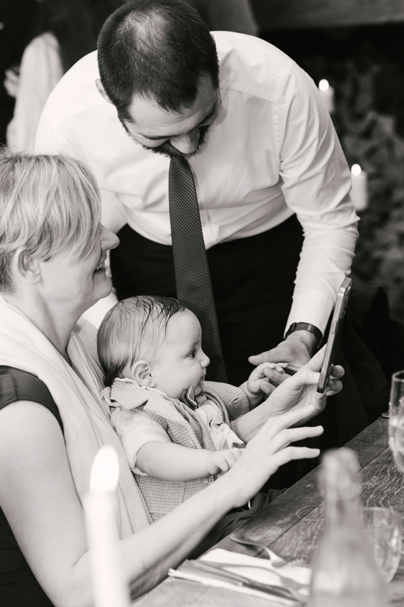 Father and grandmother holding the baby together.