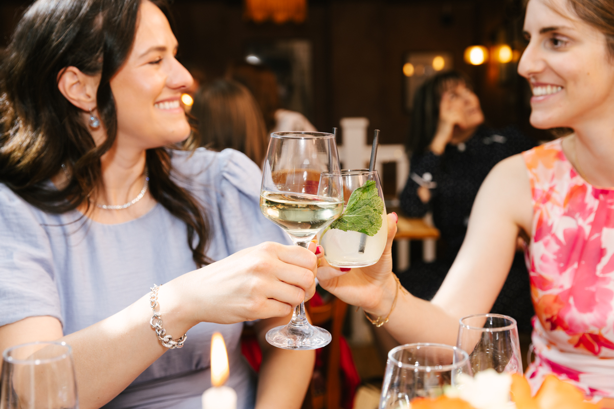 Mother and godmother raising glasses in a toast.
