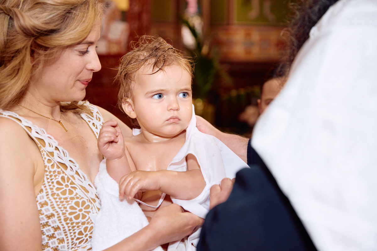 Little boy in white towel after his christening.
