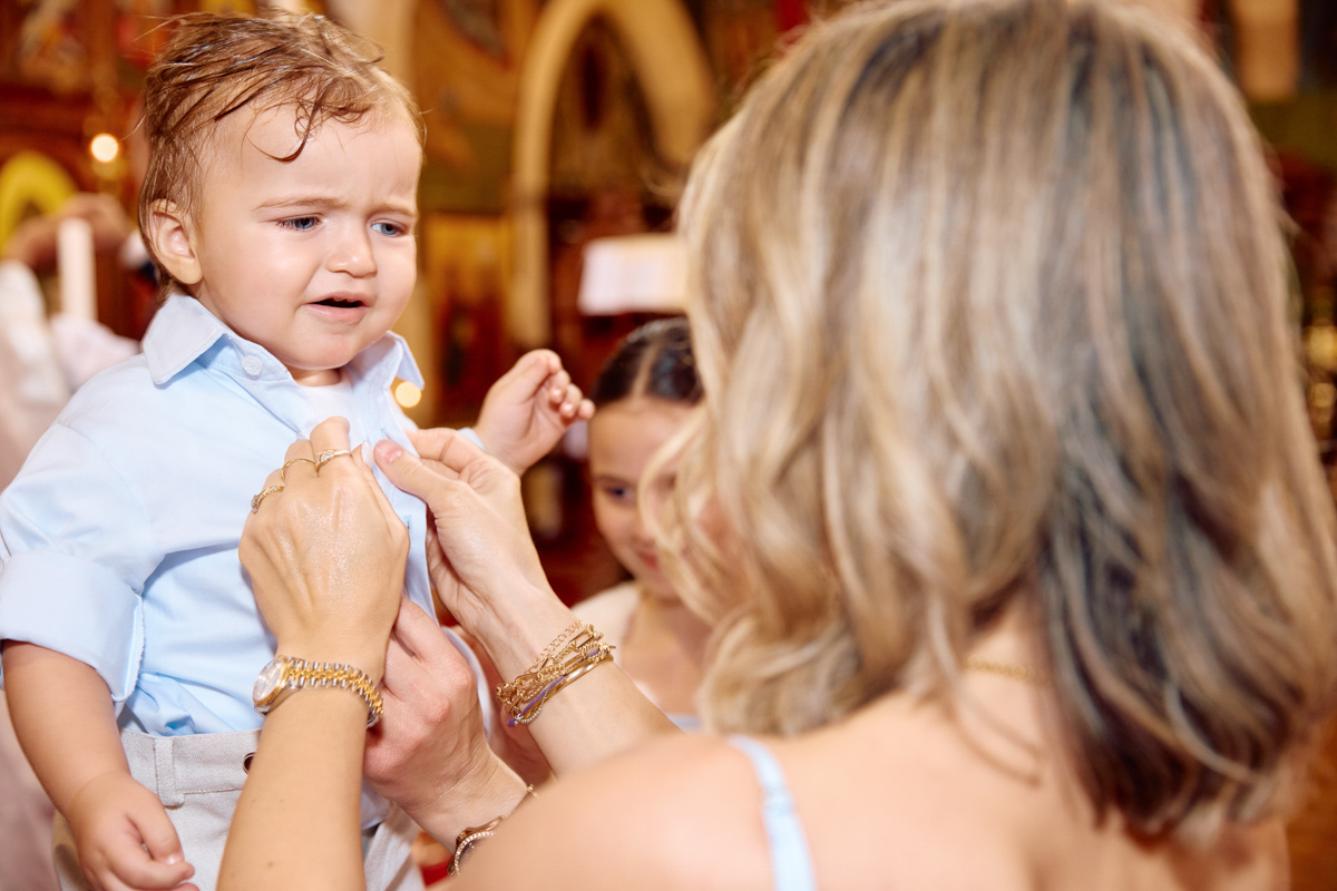 A baby is getting changed after his christening at a church.