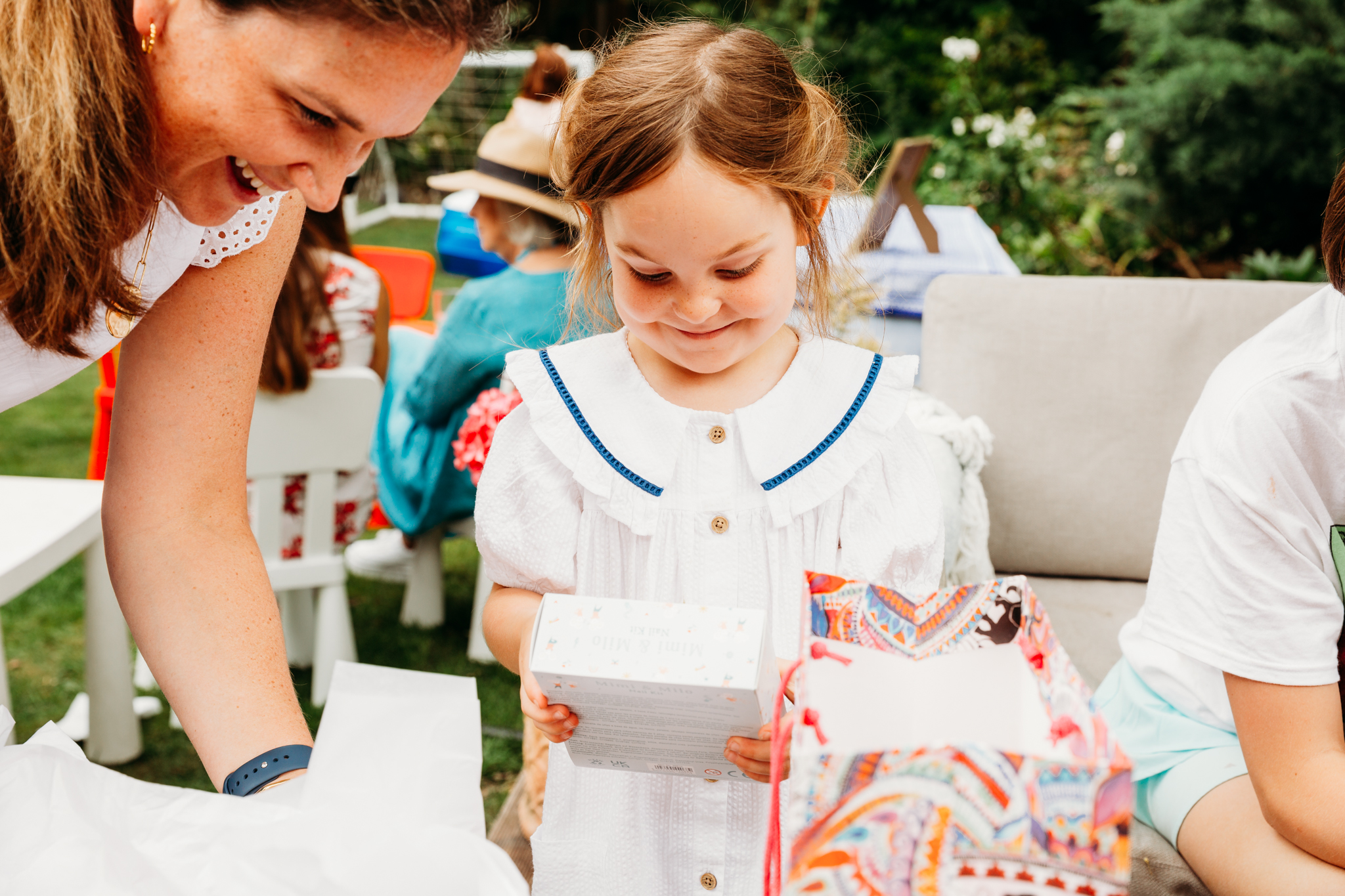 A little girl smiling while seeing her present.