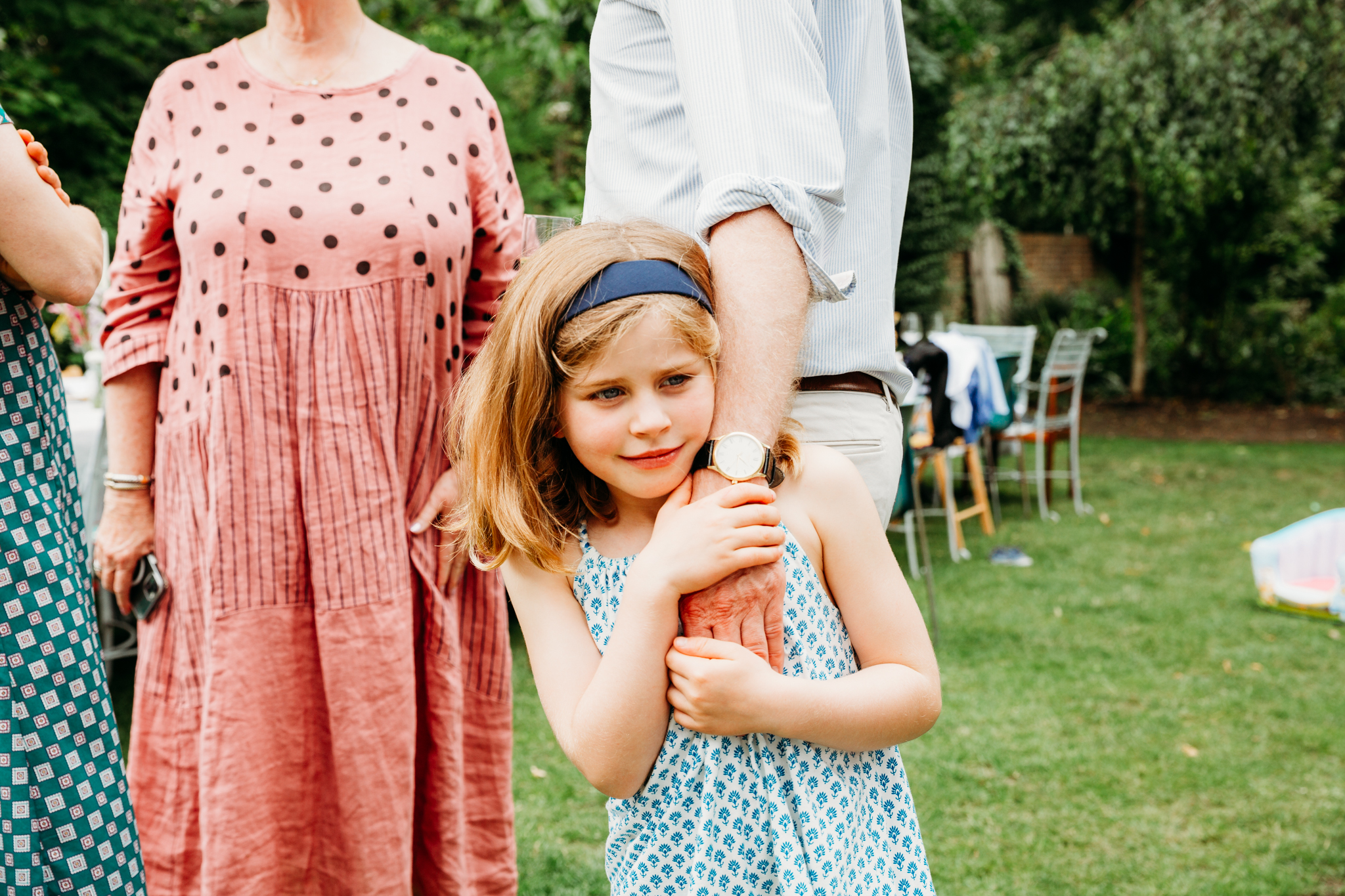 A little girl holding her dad by his hand.
