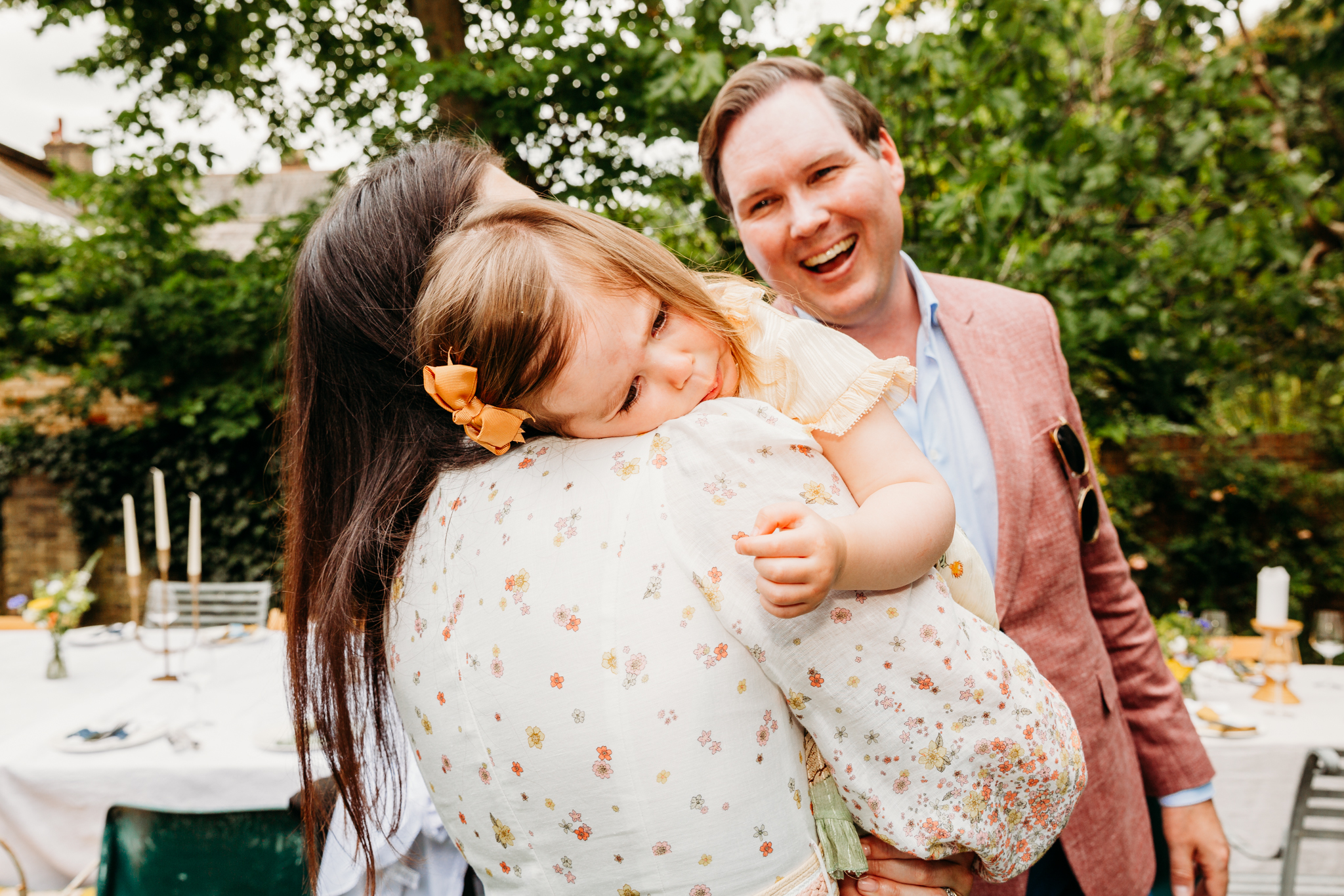 A little girl crying on her mum's shoulder.