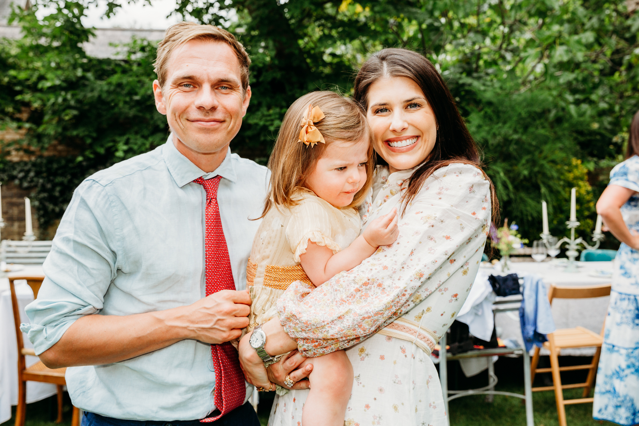 A mum holding her little girl and a man standing next to them.