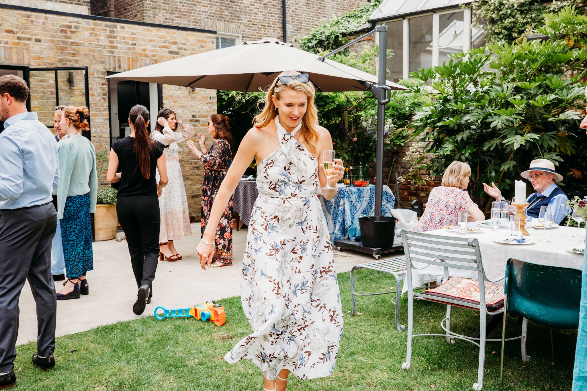 A woman walking holding a glass of champagne.