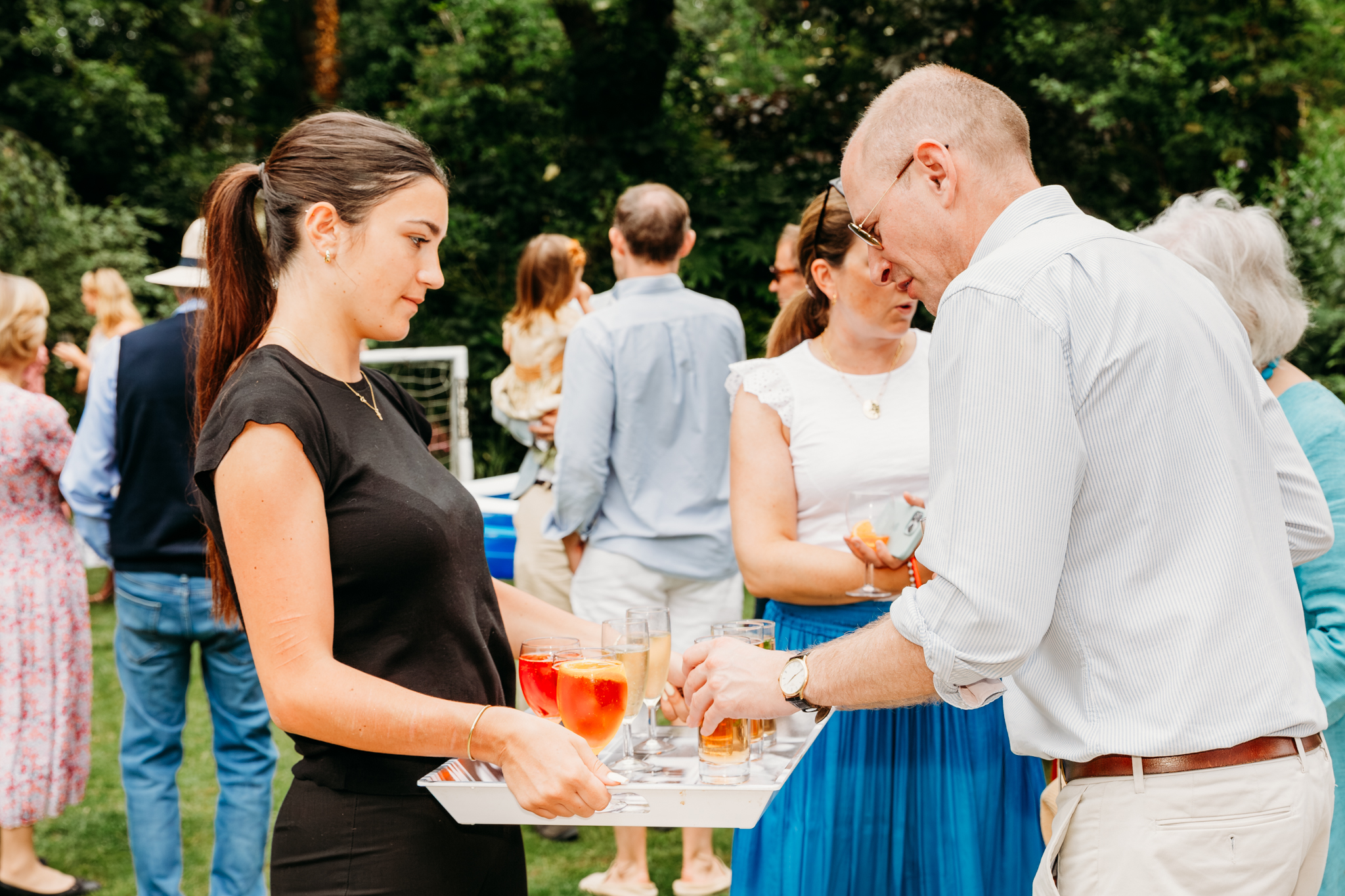A man grabbing a drink from a tray.
