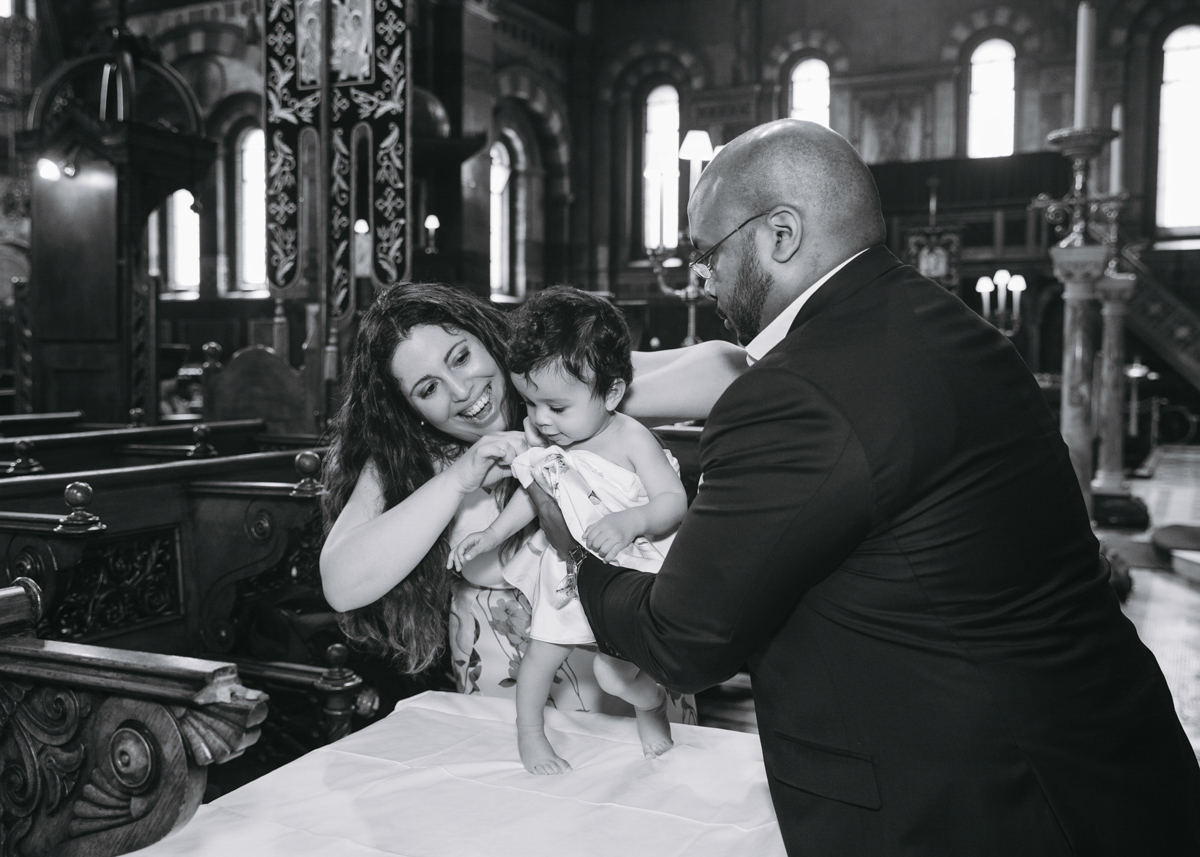 Mumm and dad dressing up their little girl after her christening.