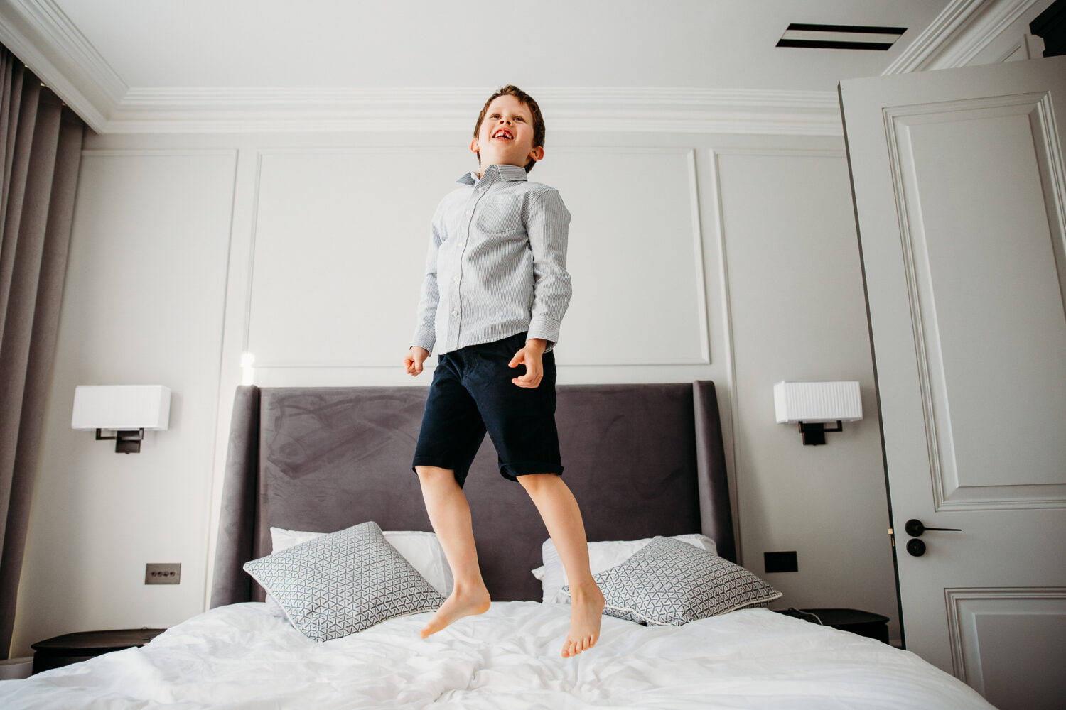 Little boy jumping on mum and dad's bed.