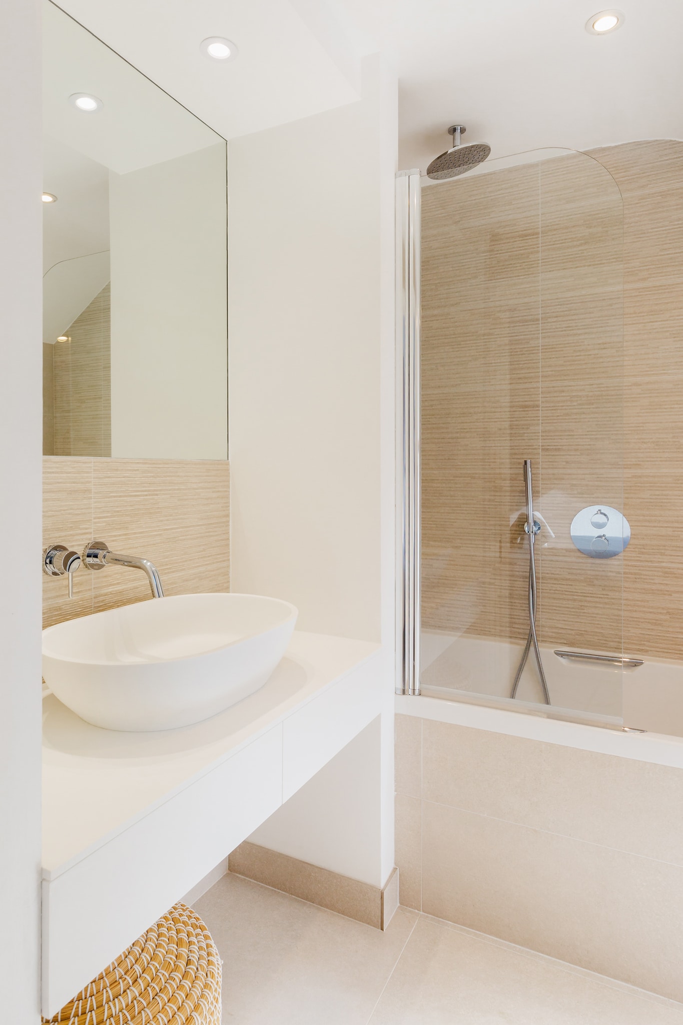 Modern bathroom with white vanity, large walk‑in shower, beige wall tiles, tiled floor.