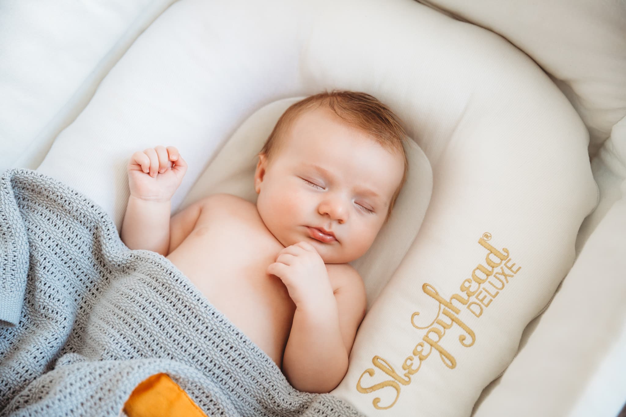 Top view of a baby sleeping peacefully in his cot.