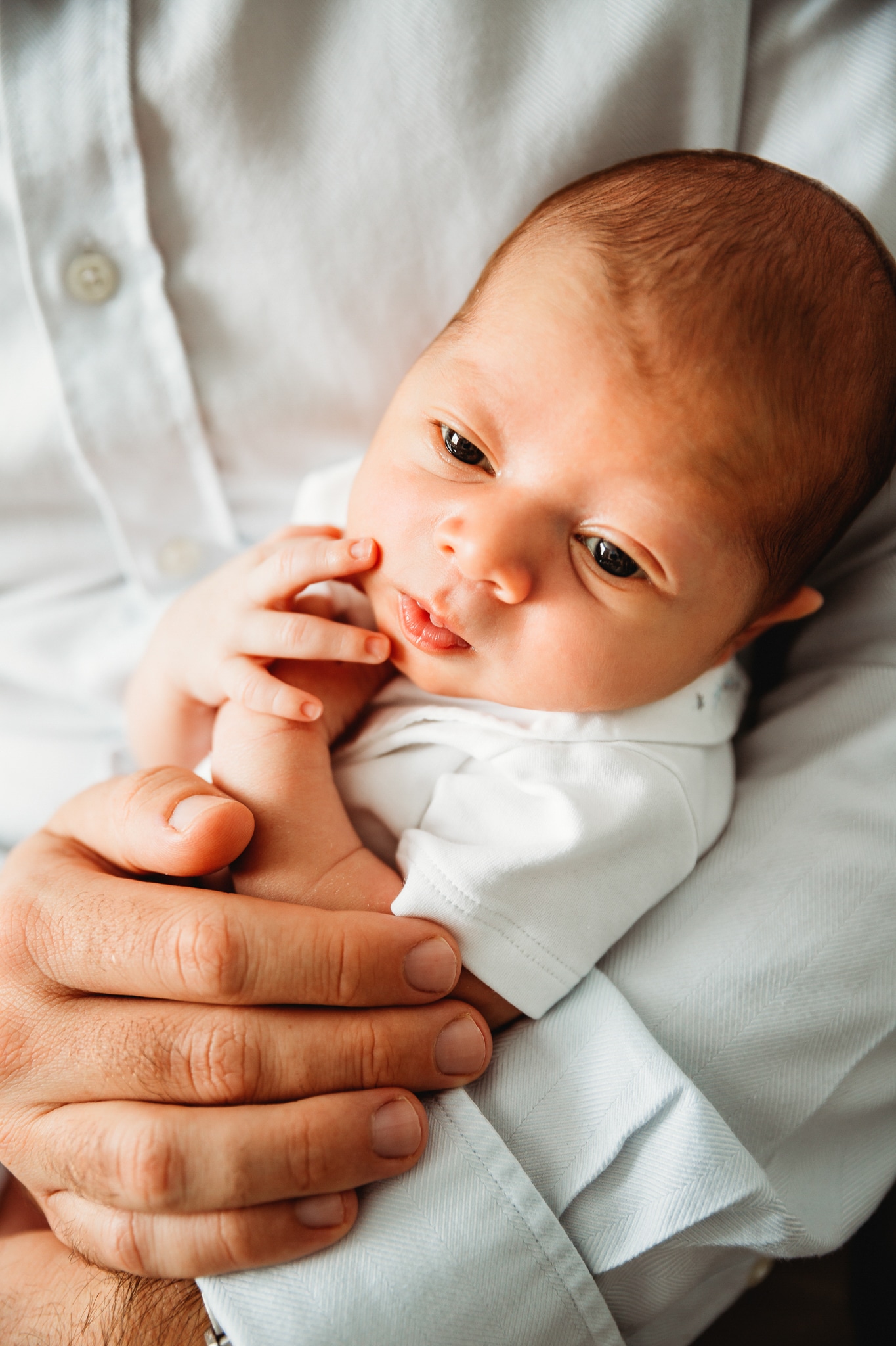 Little baby in his dad's arms.