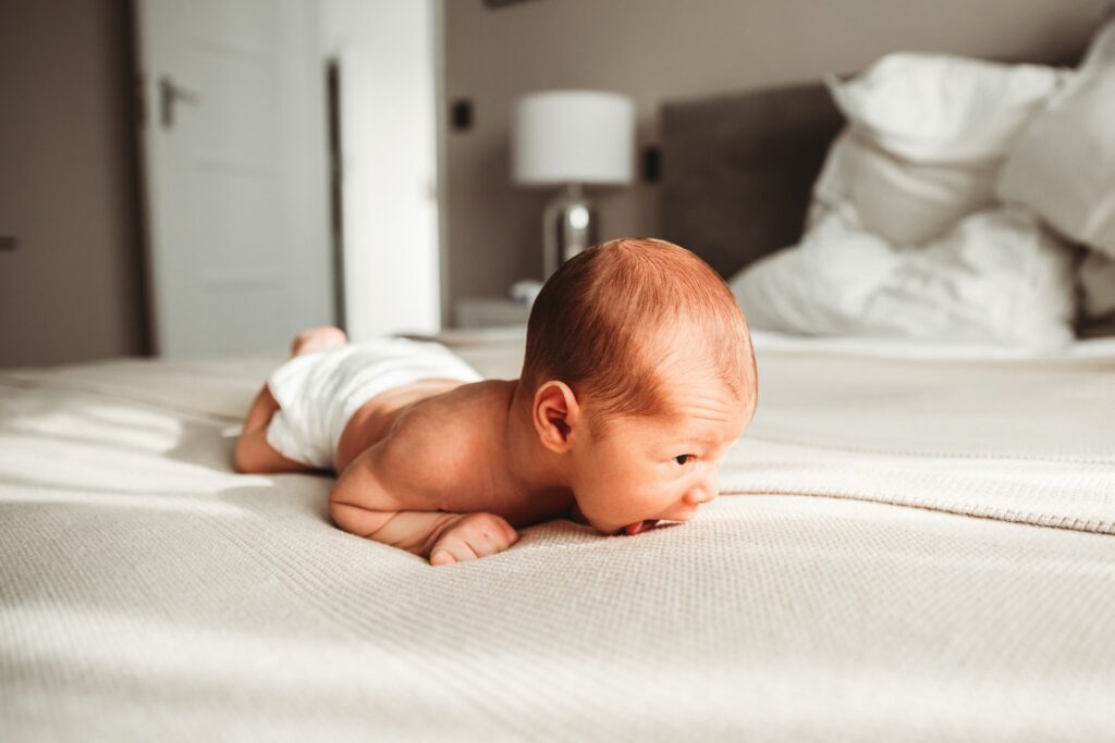 Newborn baby on his tummy trying to support himself.