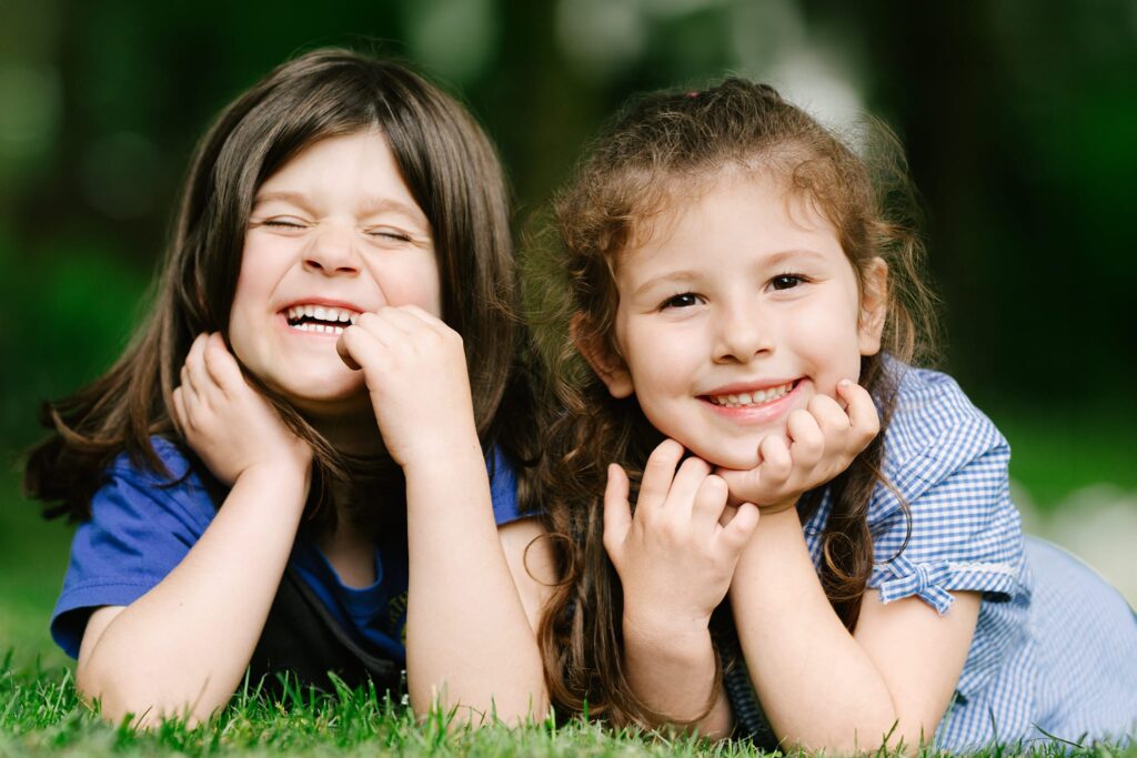 2 little girls smiling at the camera.